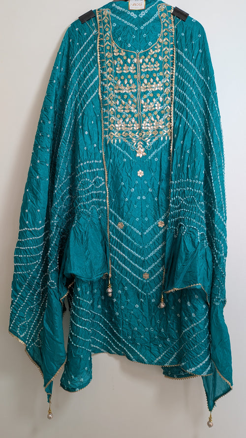 Teal embroidered traditional outfit on a white background