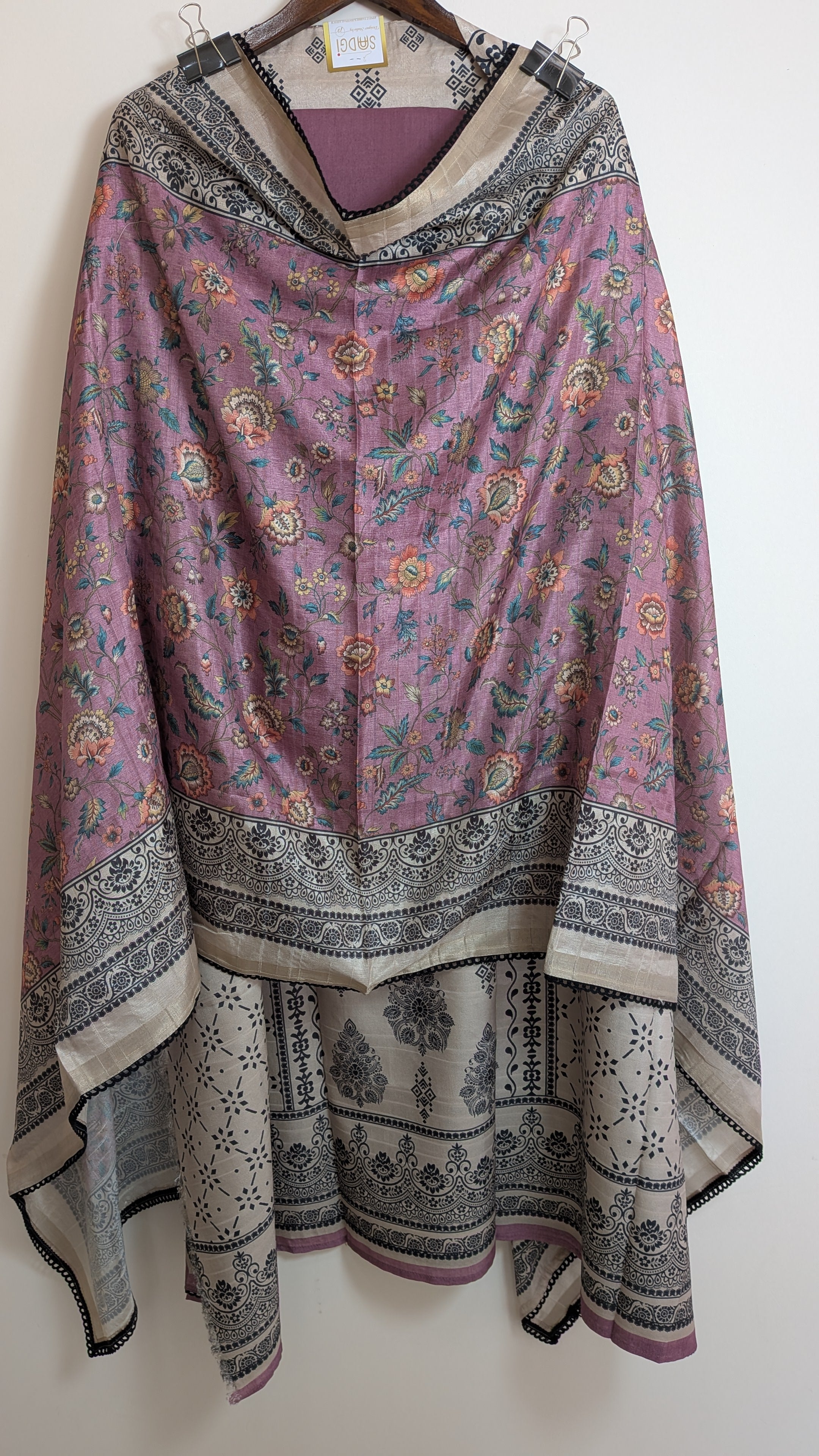 Floral patterned shawl draped over a hanger on a white background