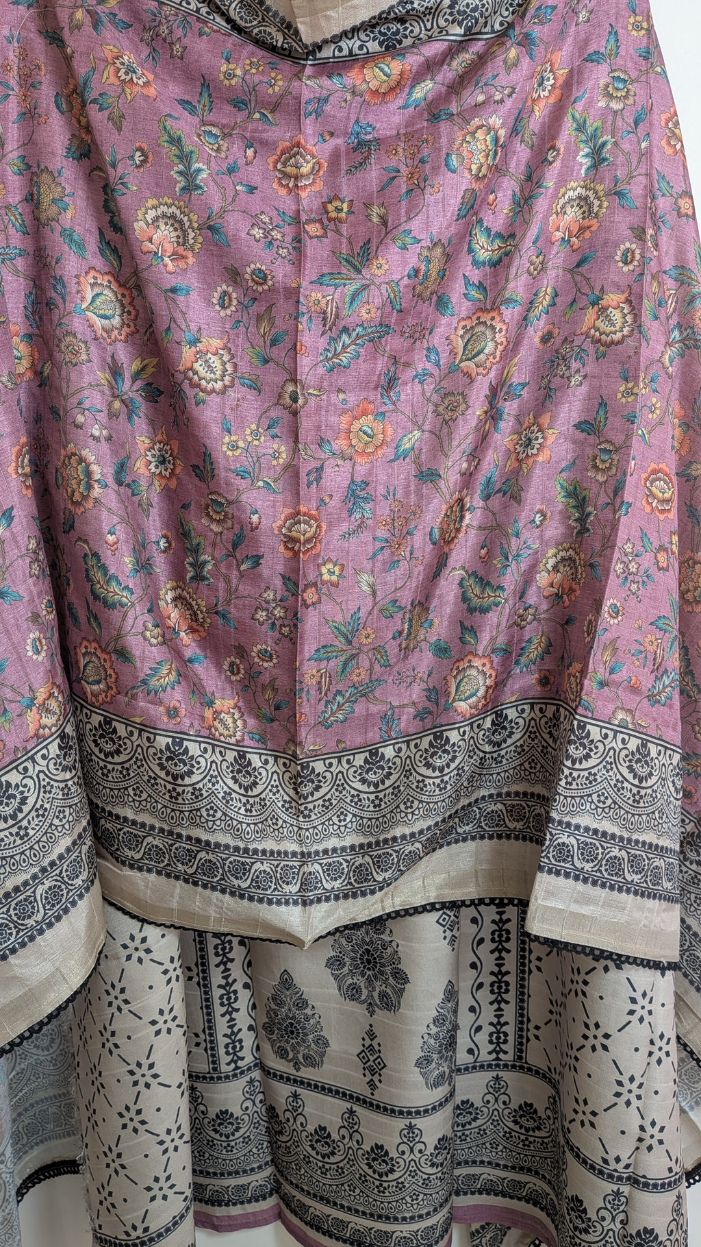 Traditional pink and black patterned fabric with floral designs