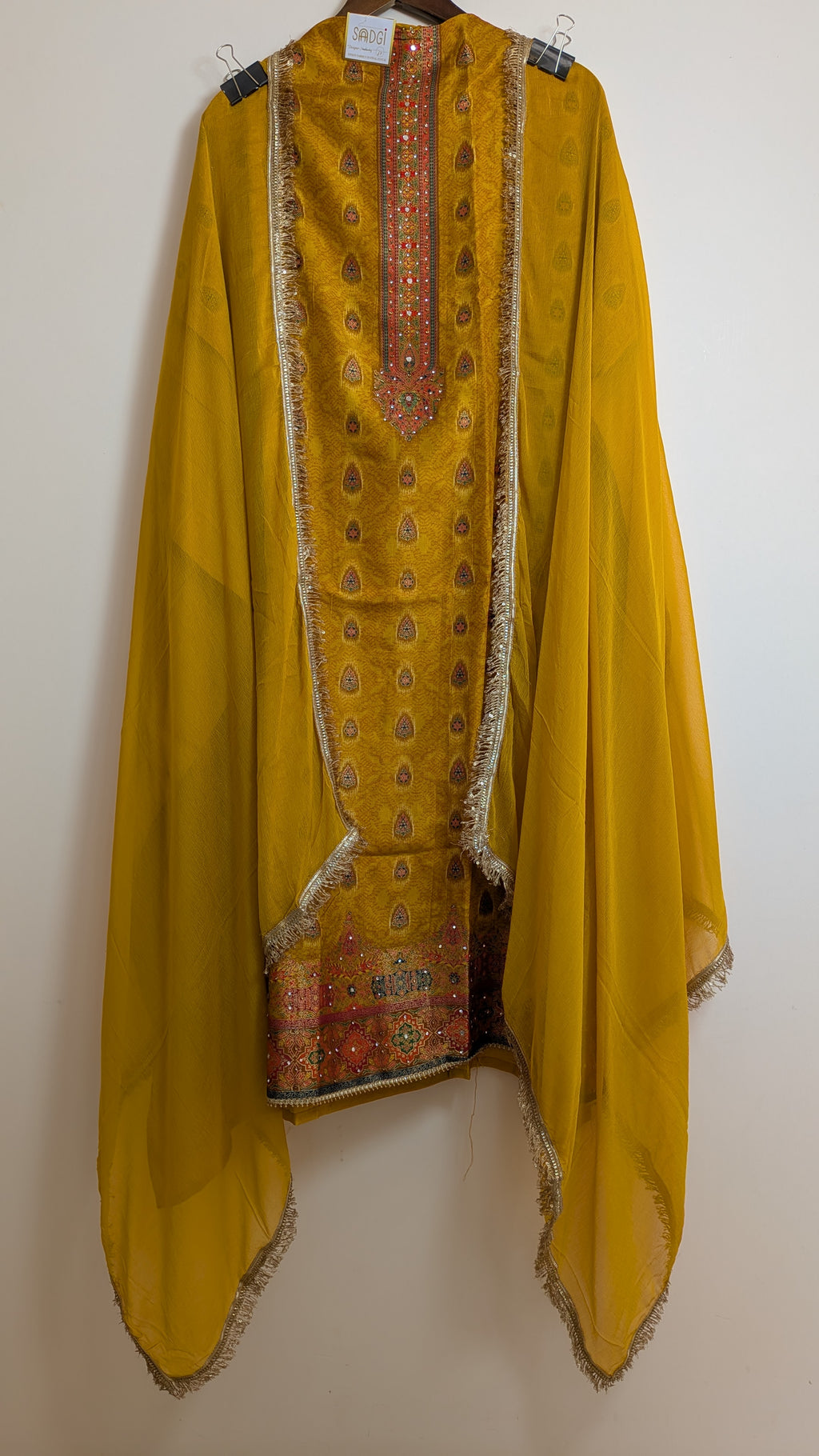 Yellow traditional outfit with intricate patterns on a white background