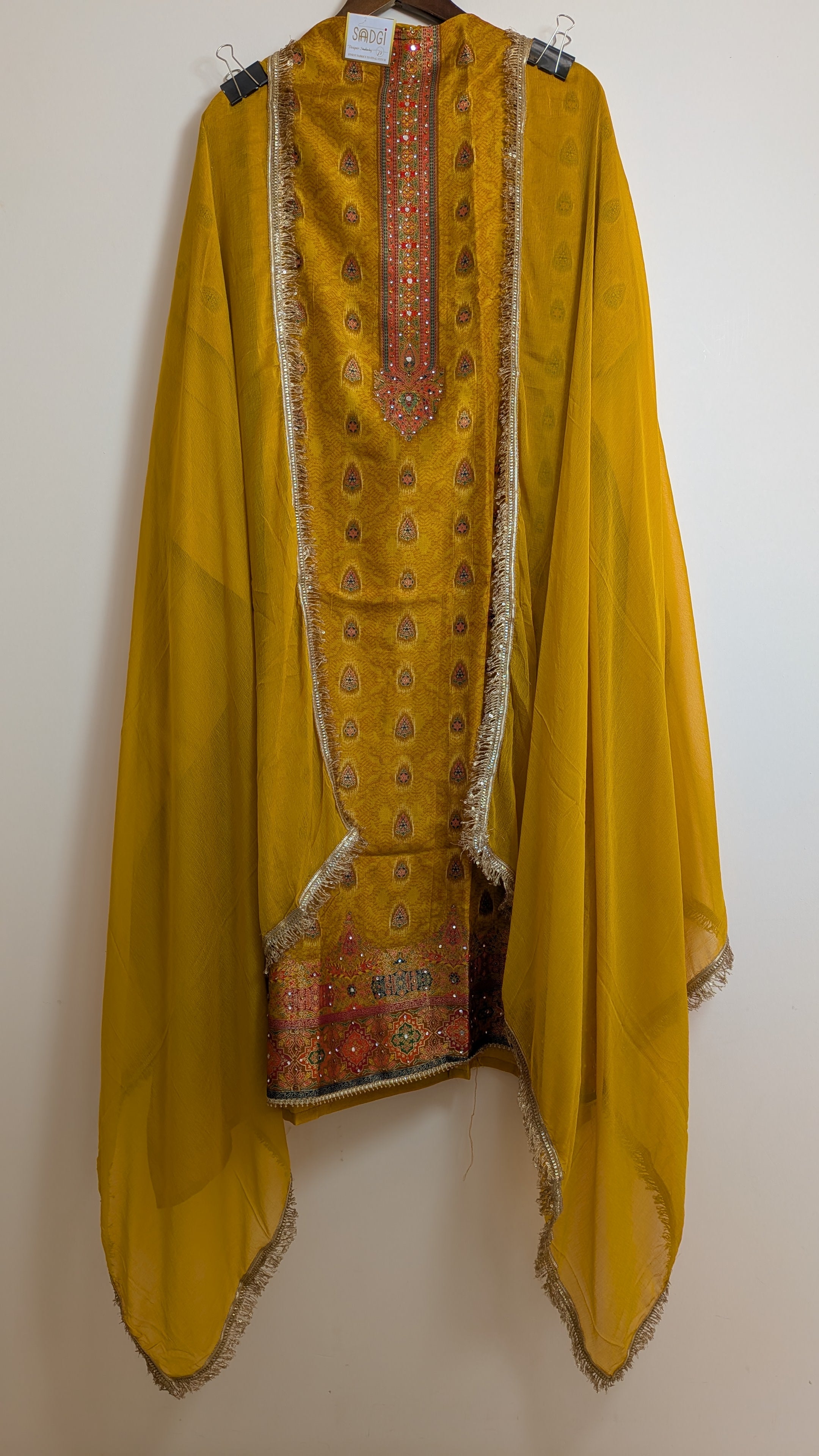 Yellow traditional outfit with intricate patterns on a white background