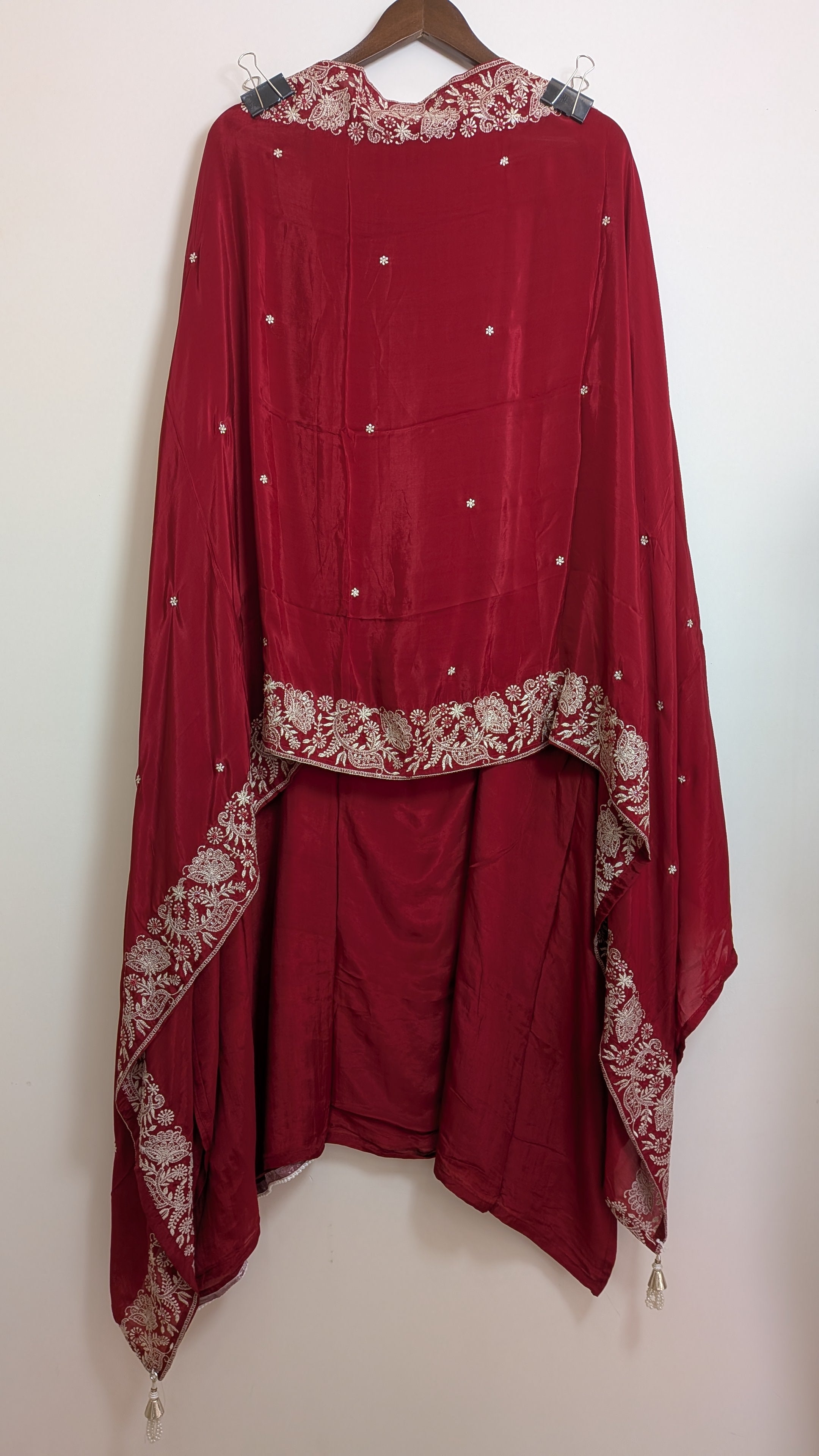 Red traditional outfit with intricate embroidery on a white background