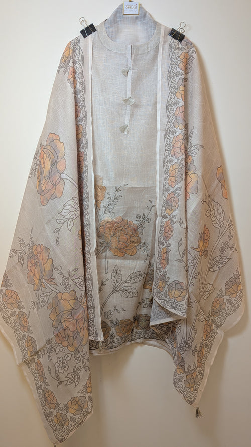 Light-colored floral-patterned shawl draped over a light shirt on a hanger against a white background