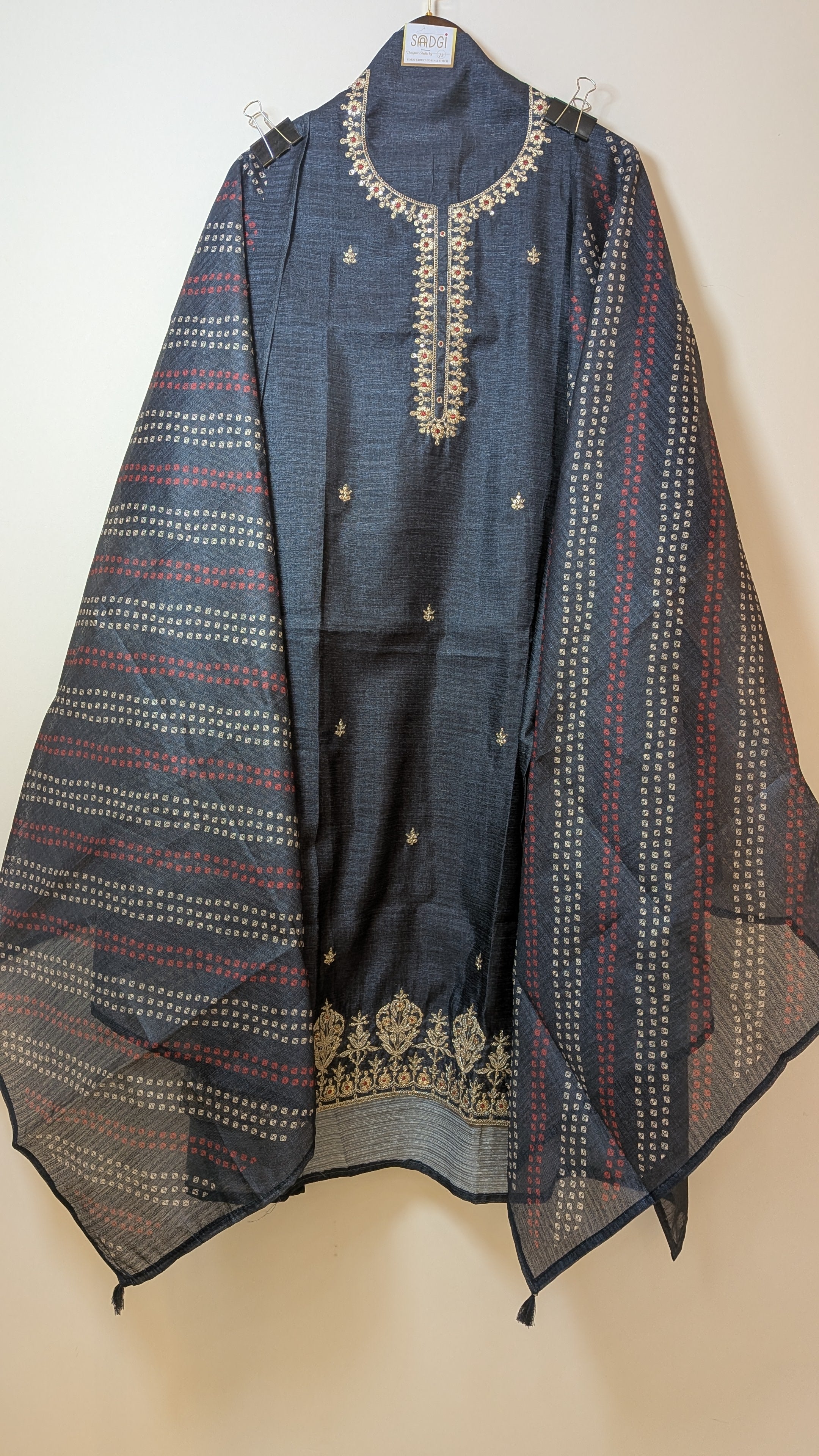 Blue embroidered garment on a beige background